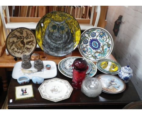 A large ceramic charger decorated with an owl and a collection of ceramics and glassware