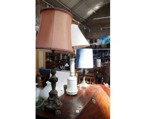 A rococo style giltwood and ebonised table lamp and two similar