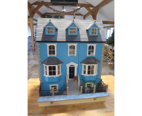 A large dolls house modelled on an Edwardian four floor house with furniture and accessories and electric lighting, in three 