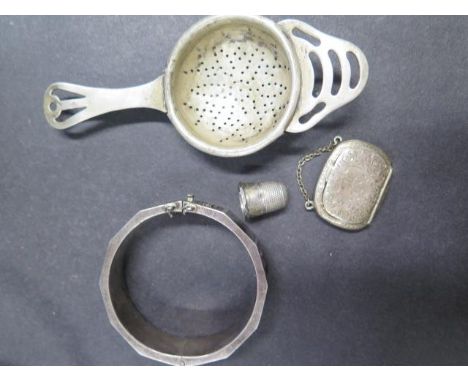 A silver enamel bangle by Topazio, a silver thimble, a silver strainer and a silver snuff box in the form of a handbag with a