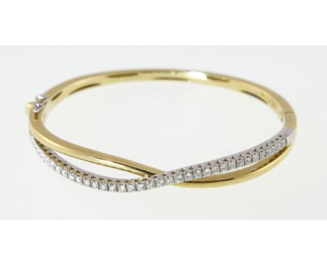 A diamond set twist bangle stamped 750 'Raima', approx total diamond weight 1.00ct & 24.6gms