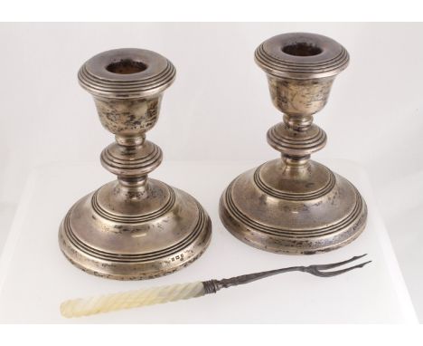 A pair of silver dwarf candlesticks 120mm high, H/M B'ham 1967, together with a silver & mother-of-pearl pickle fork H/M B'ha