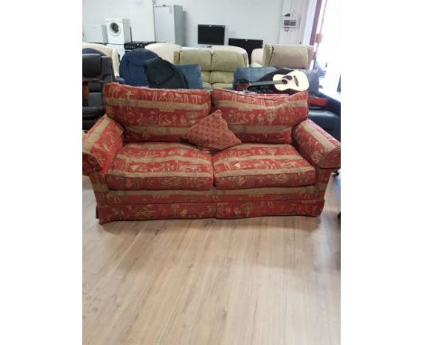 A TWO SEATER SOFA UPHOLSTERED IN EGYPTIAN PATTERNED