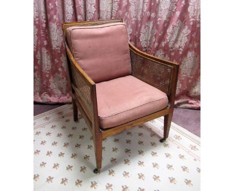 Edwardian mahogany framed Bergere armchair with canework panels and loose back and seat cushions on square tapered supports w