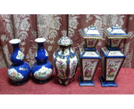 Garniture of three Worcester style vases decorated with exotic birds amidst foliage in reserve panels on a blue scale and gil