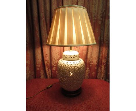 Chinese style two light table lamp, the ginger jar shaped body reticulated with bamboo and foliage, on turned wooden base wit