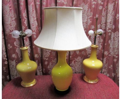 Pair of yellow glazed mallet shaped two light table lamps on gilt bases 50cm, and a yellow glazed baluster shaped table lamp,