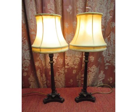 Pair of Regency style bronzed candlestick type table lamps, fluted tapering columns with urn sconces on three acanthus cast s