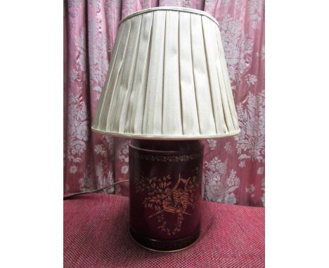 Red toleware table lamp, the tea canister shaped body decorated in gilt with musical trophies, pleated shade, H47cm 