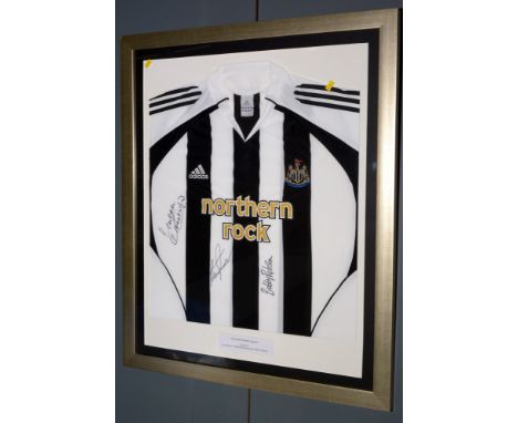 A Newcastle United football shirt, signed by "Legends" Alan Shearer, Malcolm Macdonald and Bobby Robson, in glazed gilt frame