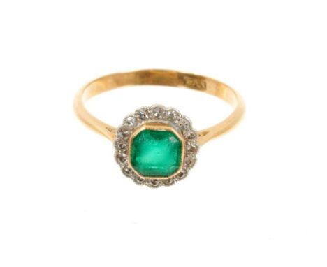 Antique emerald and diamond cluster ring with an octagonal step cut emerald measuring approximately 5.5m x 5.6mm, surrounded 