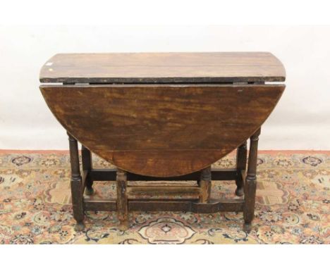 Early 18th century oak gate leg table, with oval hinged top end frieze drawer raised on turned and block understructure, 96 x