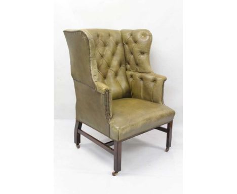 Georgian style leather button upholstered wing armchair, of broad proportions, raised on square internally chamfered supports