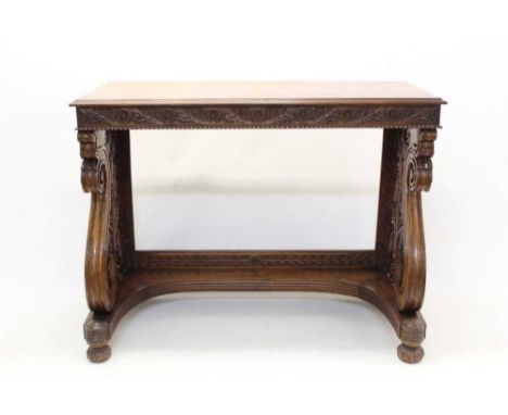 19th century Anglo-Indian teak console table, rectangular top raised on ornately carved scrolled end supports and carved bun 