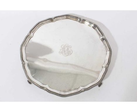 1920s silver salver of hexagonal form with central engraved monogram and stylised gadrooned and shell border on four scroll f