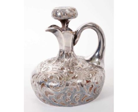 Late 19th/early 20th century cut glass claret jug of compressed baluster form with star cut base and loop handle, encased wit