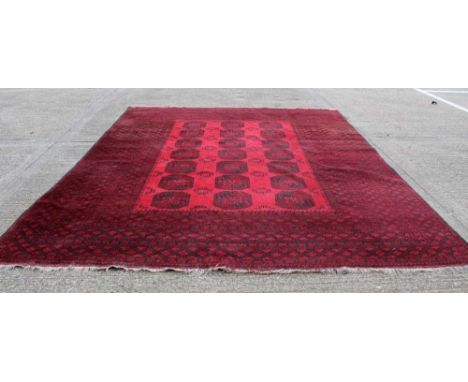 Large Afghan carpet, with three rows of seven quartered guls in multiple geometric borders, on red ground, 380 x 300cm