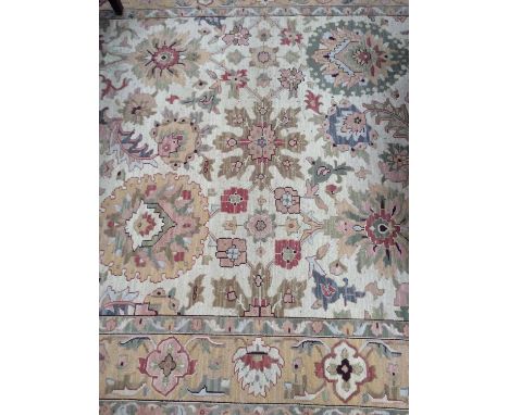 Large Indian carpet, with meandering lotus ornament on cream ground in comforming borders, approximately 220 x 310cm