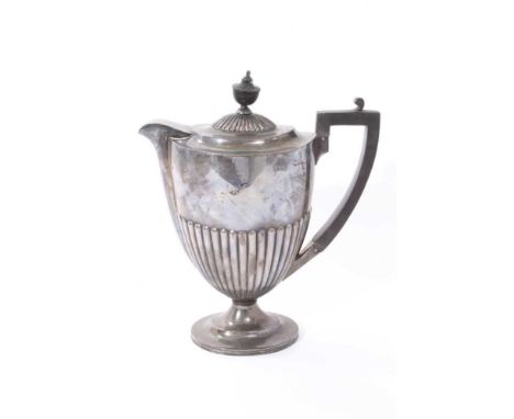 1920s silver hot water jug of urn form, with half fluted decoration, angular ebony handle and hinged domed cover, with turned