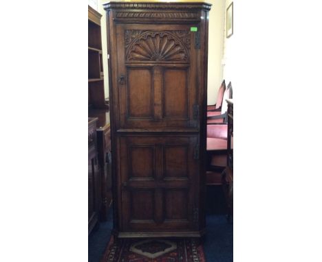 A good quality rack straw oak reproduction two door floor standing corner cupboard with carved decoration