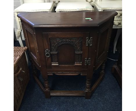 An Old Charm hall cupboard with tapered front with carved single door, all on turned legs, bears label to rear.