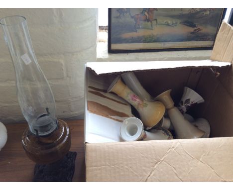 A paraffin lamp along with a box of candlesticks decorated with flower pattern.