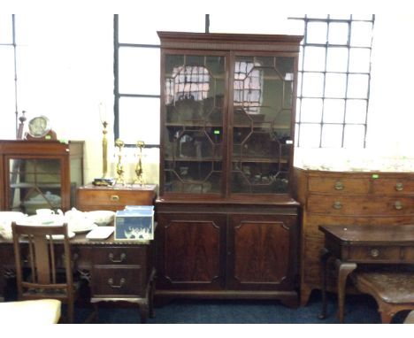 A mahogany glazed and beaded topped bookcase with two door cupboard base