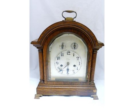 Continental oak-cased bracket clock, c. early 20th century, the arched shaped clock with twin reeded Corinthian pillars, glaz