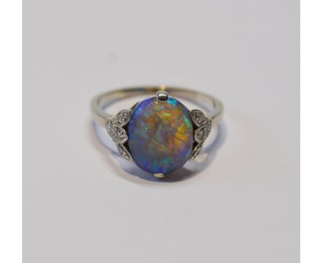 Art Deco period black opal and diamond ring, the cabochon approximately 10mm x 8mm, in trefoil shoulders each with three eigh