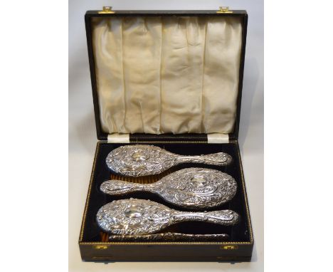 Embossed silver four-piece toilet set of two brushes, a comb and a mirror, Birmingham 1893, cased.