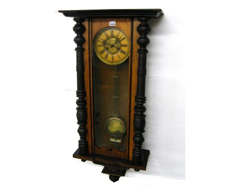 Walnut and ebonised two train Vienna wall clock, the 7" dial within a glazed and turned pillared case, 43" high (missing corn