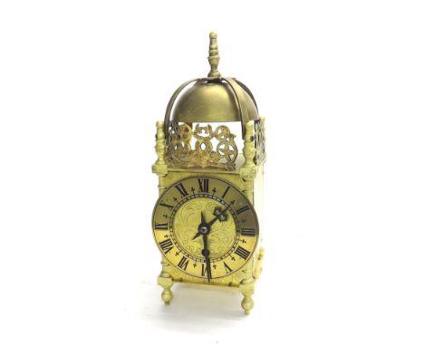 Small brass lantern clock, the 4" chapter ring enclosing an engraved centre and surmounted by a pierced fret strapwork bell a