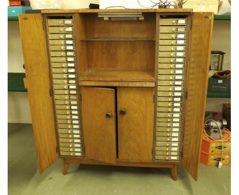 Maple cabinet containing a large assortment of watchmakers accessories and tools, including a quantity of movements; together