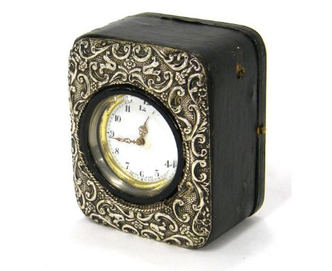 Small leather travelling clock timepiece with carriage platform type movement, the 1.5" circular dial within a silver embosse