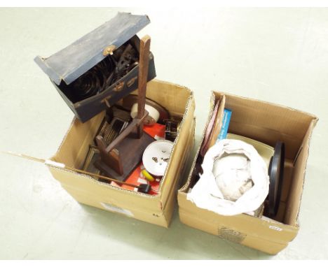 Two boxes of sundry clock accessories including a box of mainsprings and winding tool, various dials, clock cases, dismantled