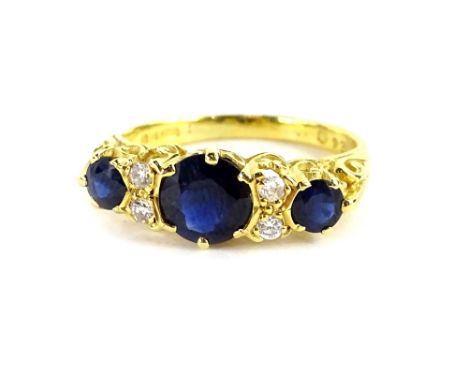 An 18ct gold gypsy ring, set with three sapphires and four tiny diamonds, the round brilliant cut sapphires with central ston