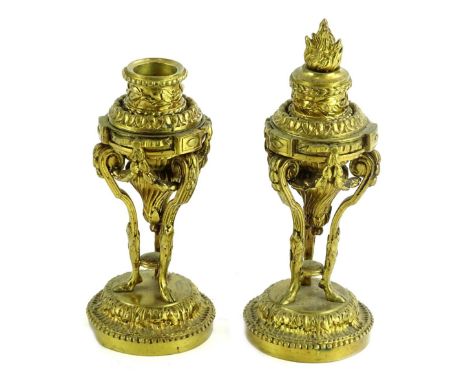 A pair of late 19thC French gilt metal cassolettes, each cast with flame finial, scrolls, swags etc., on three feet with dome