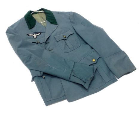 A German Third Reich style green jacket, applied with army pattern and National eagle badge, unmarked. (AF)