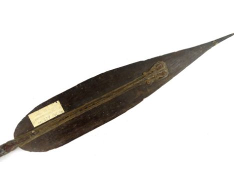 A Papua New Guinea tribal paddle, with carved blade, tapering handle and shaped finial, bearing label stating Aborigine boat 