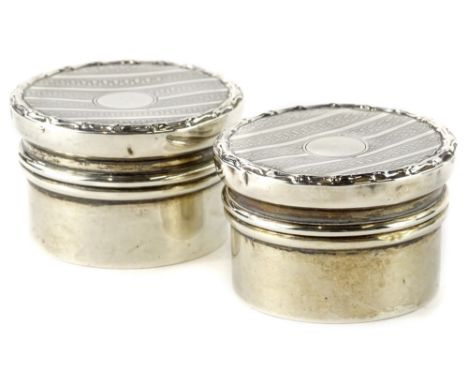 A pair of Edwardian silver circular dressing table jars, engine turned decoration, Birmingham 1909, 1¼oz overall.