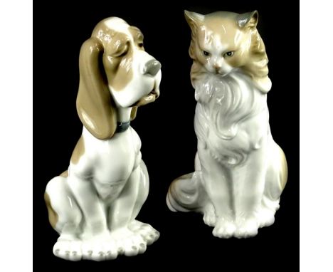 Two Nao ceramic figurines, one modelled in the form of a seated dog, the other a cat, 19cm H.