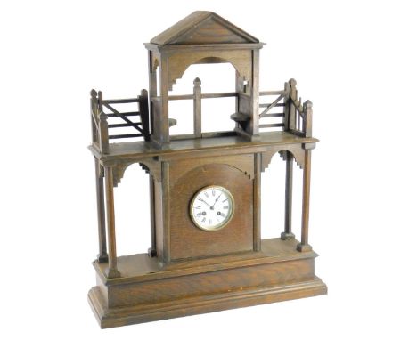 An early to mid 20thC portico shaped oak wall clock, with an associated French enamel dial, 57cm W.