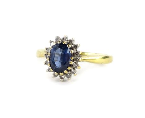 An 18ct gold sapphire and diamond dress ring, with oval cut pale blue stone, surrounded by tiny diamonds, each in claw platin