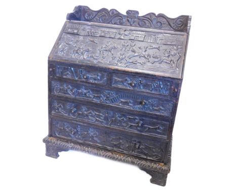 A 19thC oak bureau, carved overall with hunting scenes, fox, masks, scrolls etc., the top with a raised gallery above a fall 