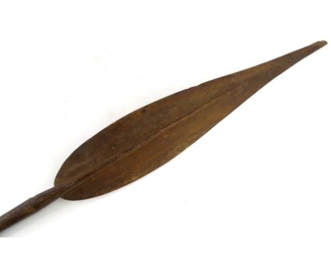 A Papua New Guinea tribal paddle, with leaf shaped blade, tapering handle with carved finial, bearing label stating Aborigine
