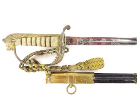 A George V British naval sword, the leather scabbard with engraved brass mounts, the blade stamped Gieves, the guard with anc