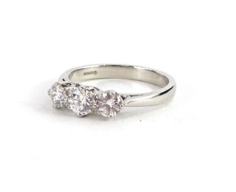 A platinum three stone diamond ring, with three round brilliant cut diamonds, each in claw setting, the central stone approx 