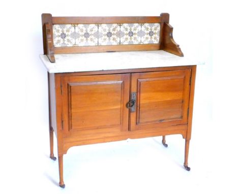 A Victorian pale walnut wash stand, the raised back inset with transfer printed tiles, above a white marble top and two panne