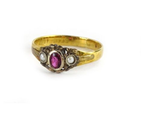 A Victorian style dress ring, set with oval cut garnet in white metal rub over setting, flanked by two seed pearls, on a late