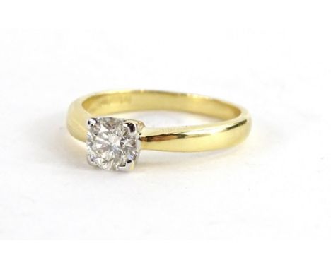An 18ct gold diamond solitaire ring, with round brilliant cut diamond in four point platinum setting, the diamond approx 0.47